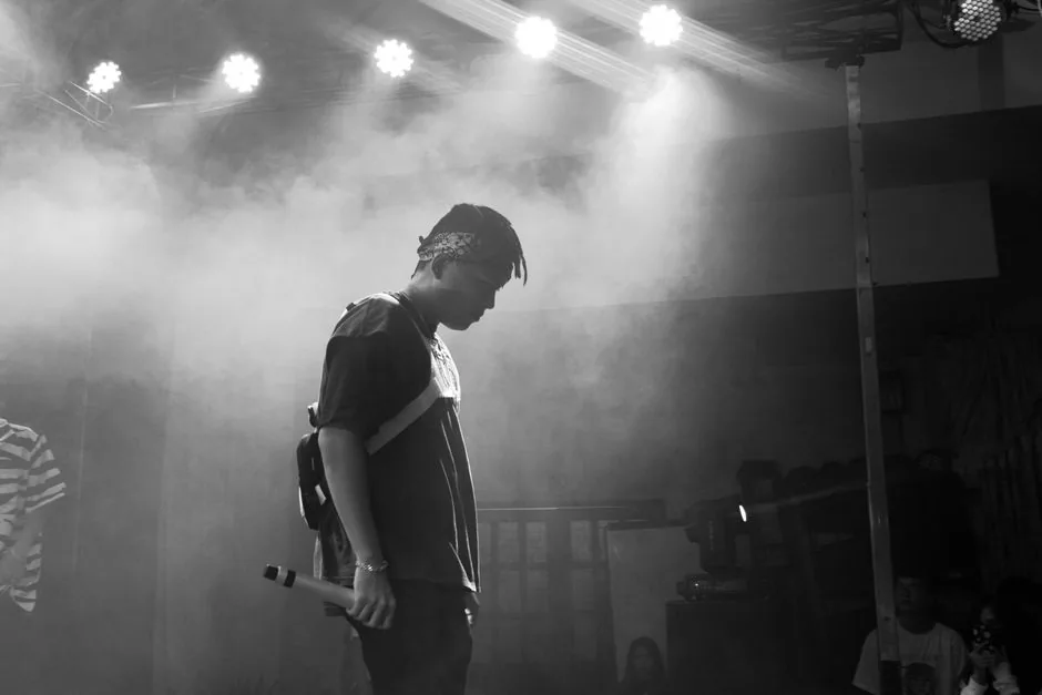 A performer on stage during a concert, black and white